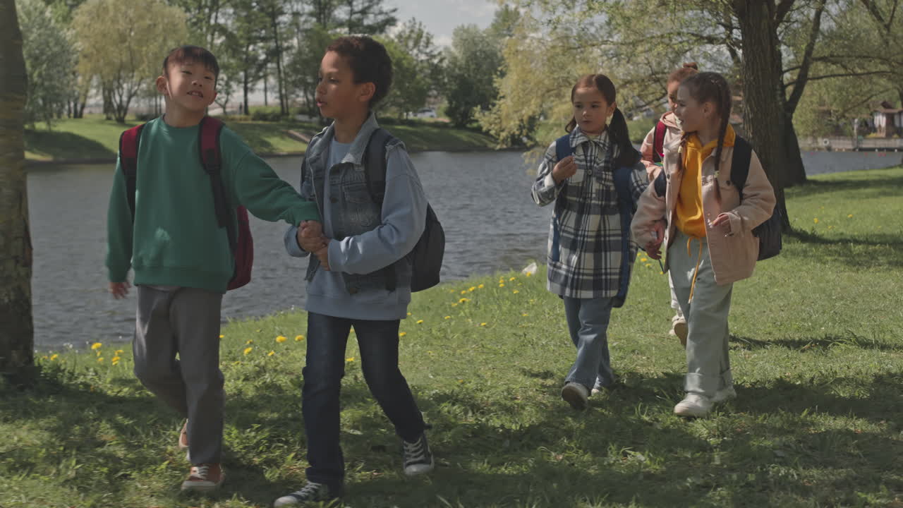 A group of children walking outdoors with backpacks