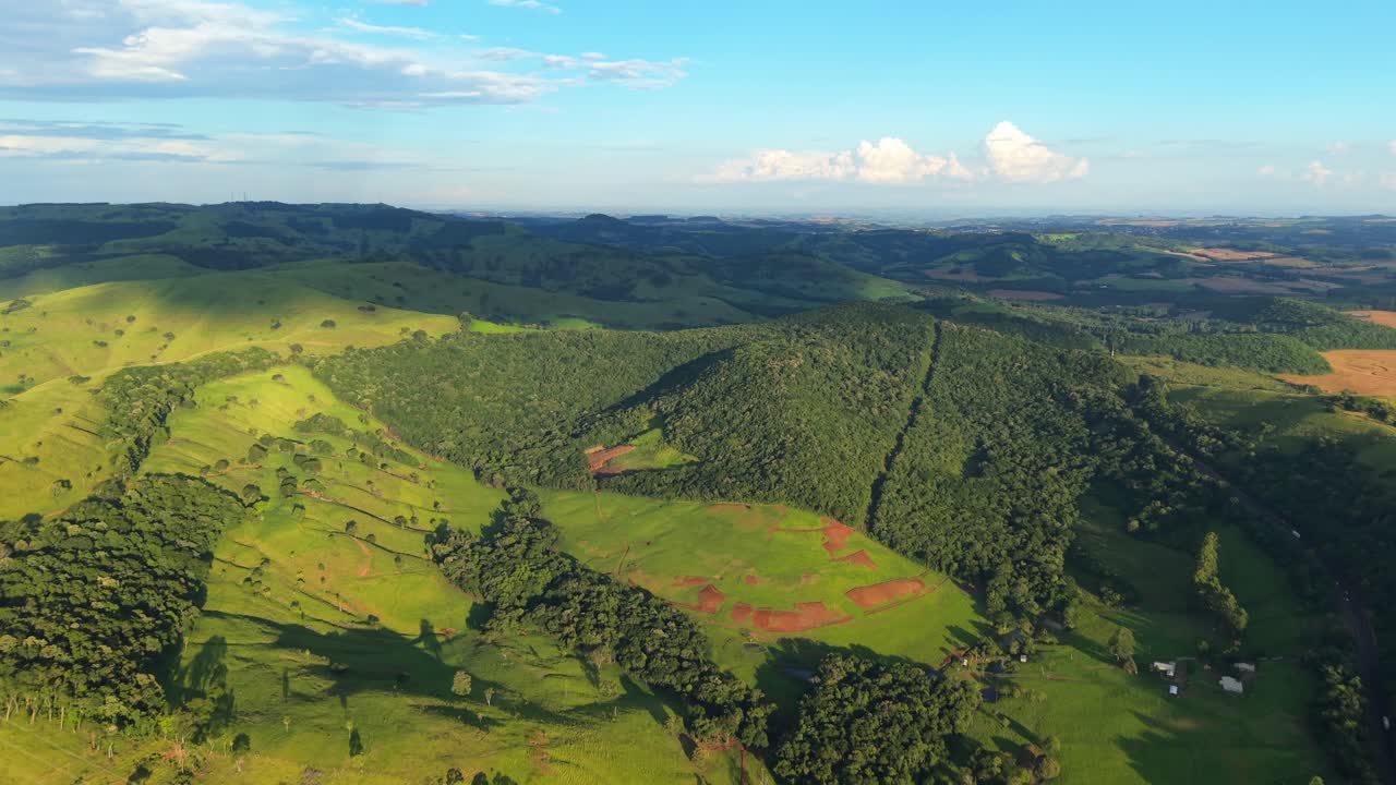 Terre agricole a pascolo con aree di pascolo e macchie di foresta a Laranjeiras do Sul, Paraná, Brasile meridionale, colline ondulate e proprietà rurali nel paesaggio della Foresta Atlantica, ripresa aerea, angolazione alta