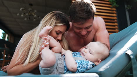 enjoying family time spent together. new-made parents entertaining their infant being with him outdoors.