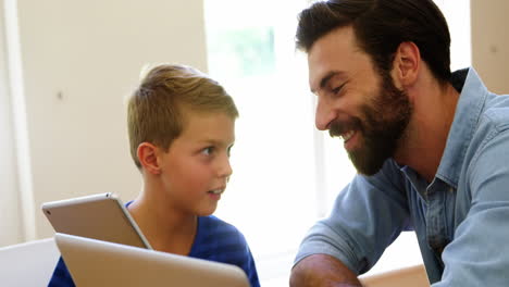padre e hijo mirando la tableta juntos