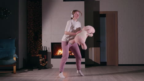 woman dancing in living room by fireplace with plush toy