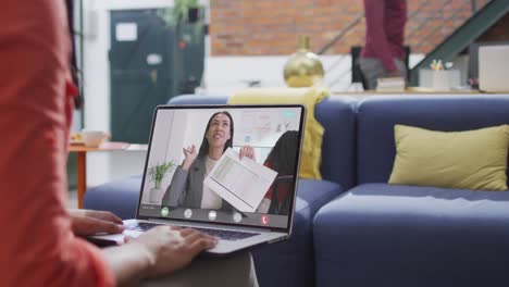 Biracial-businesswoman-using-laptop-for-video-call-with-biracial-business-colleague