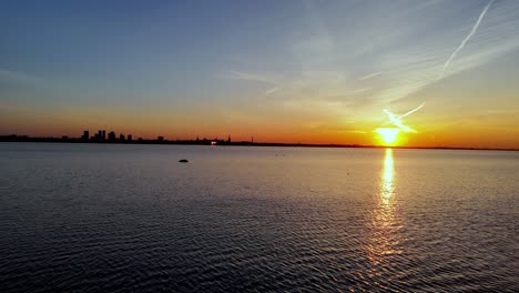 puesta de sol dorada sobre la bahía de tallin con el horizonte de la capital de estonia