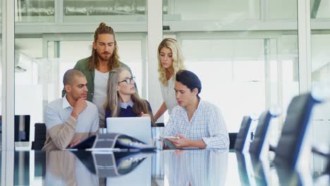 Colleagues-discussing-over-laptop-at-table-4k