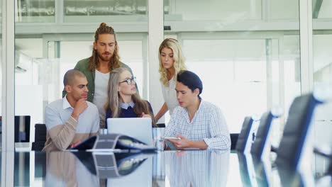 colleagues discussing over laptop at table 4k
