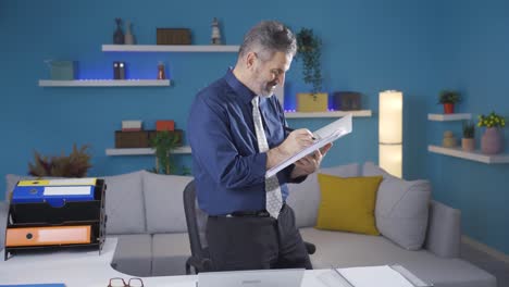 fun and pleasant working mature businessman enjoys working in his home office.
