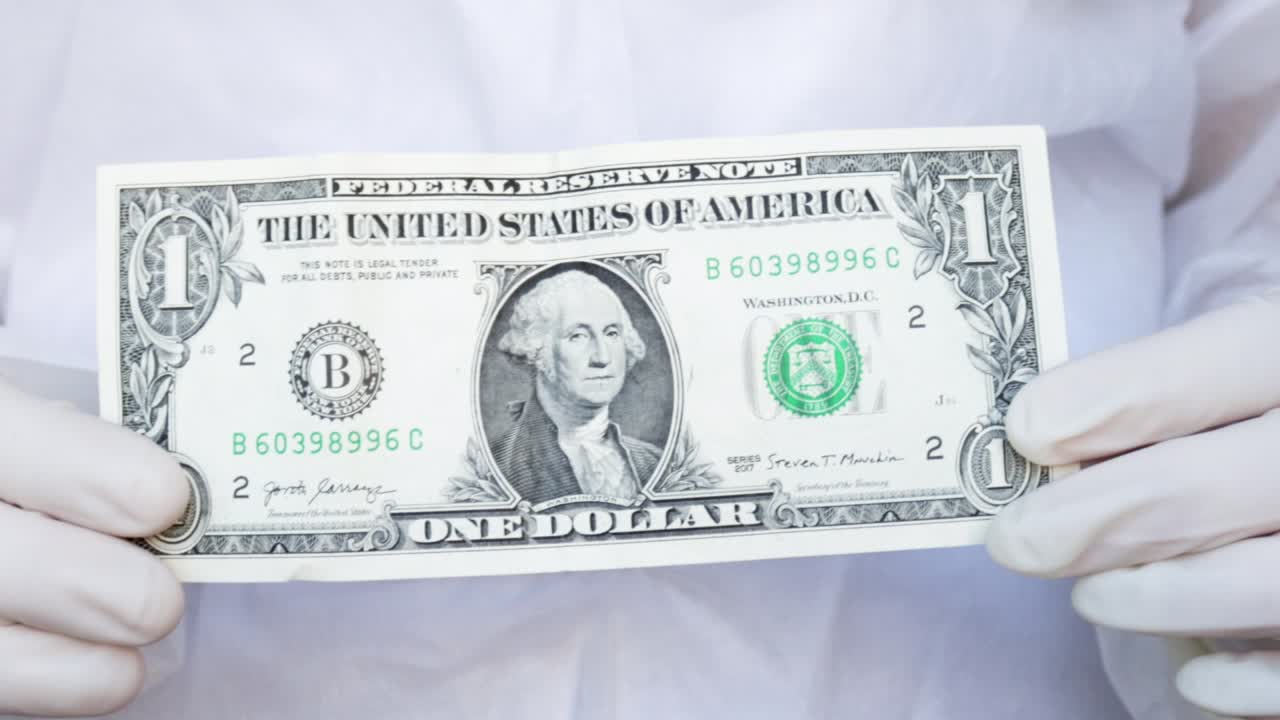 간호사 나 의사 는 양 손 에 1 달러 지폐 를 들고 있다