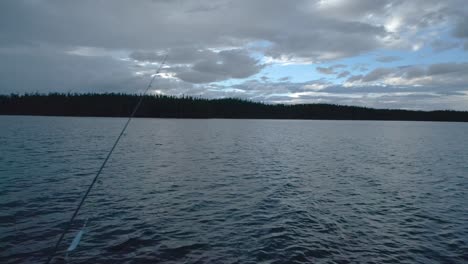 fishing rod on a lake on a cloudy evening sky