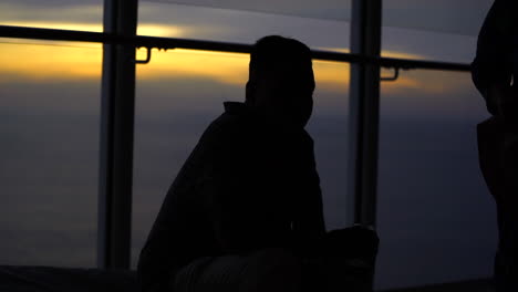 one man setting in cruise at sunset  silhouette