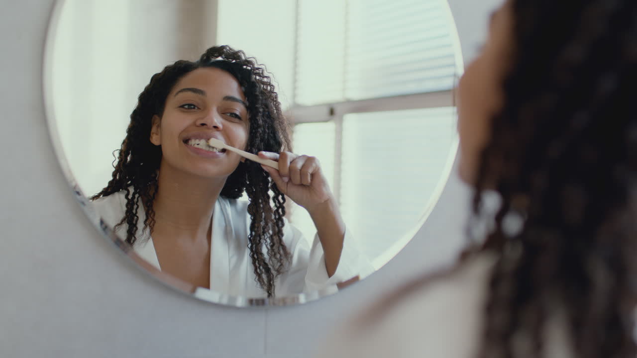 Mujer cepillándose los dientes en el baño
