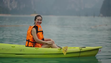 woman enjoying a calm moment in a kayak on a lake