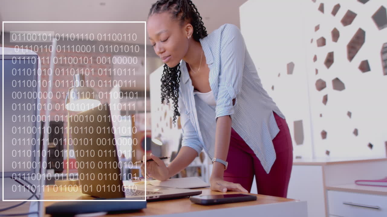 animación del procesamiento de datos sobre una mujer de negocios biracial que usa una computadora portátil en la oficina