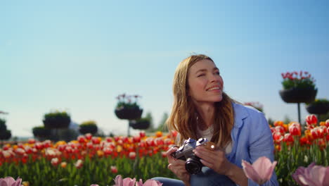 Emotional-woman-looking-at-blooming-garden.-Happy-girl-taking-photo-of-flowers.