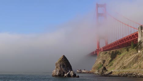 fog rolling through golden gate bridge during a calm summer morning in california