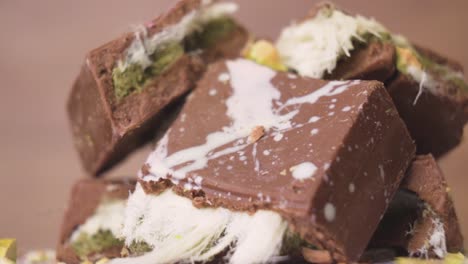 macro shot of a dubai chocolate piece decorated with pistachio bits showing rich cocoa and nut textures
