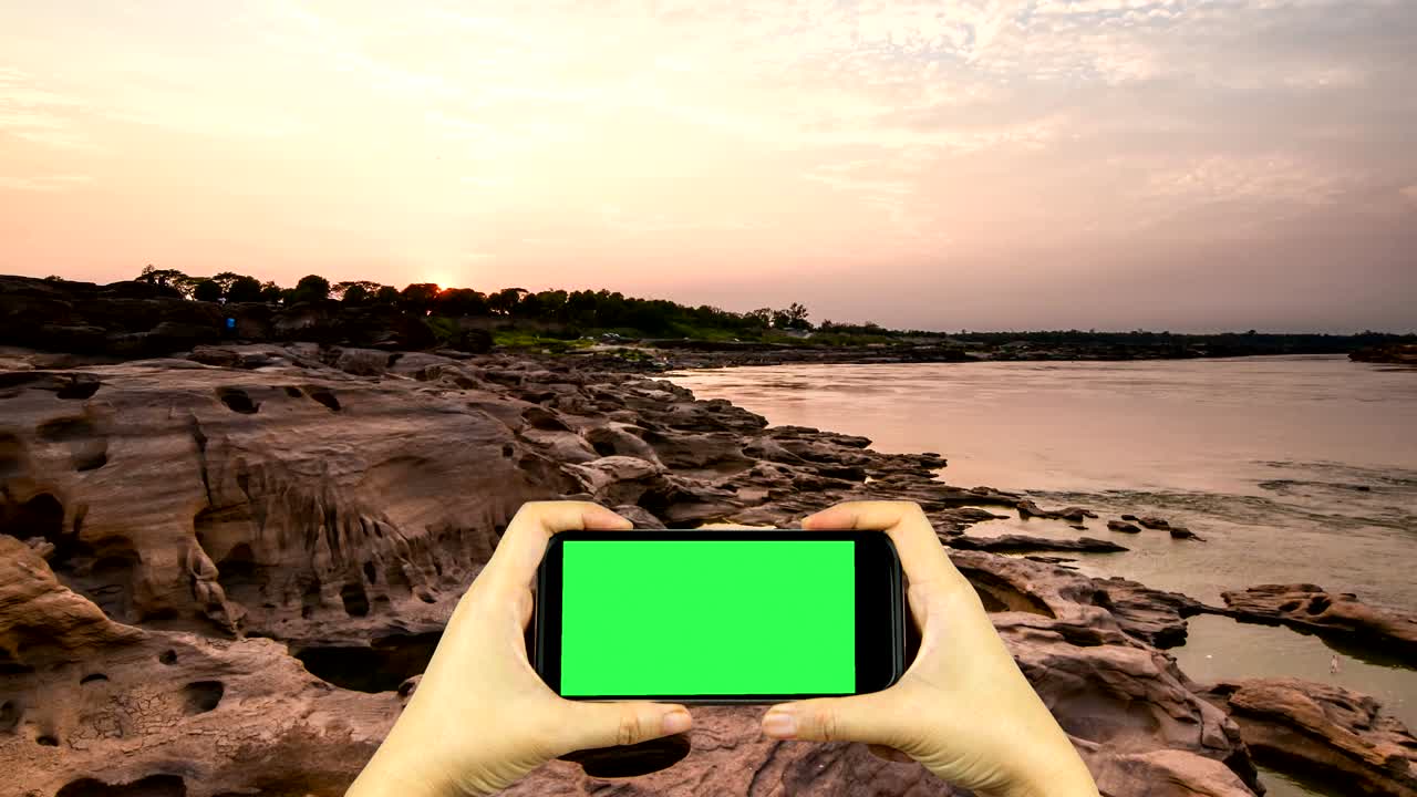 Merekam video alam dengan ponsel pintar yang memiliki tampilan layar hijau