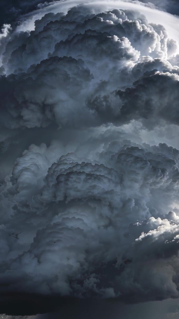 Video verticale: Cumulonembo in formazione da correnti ascensionali, che cambia forma nel cielo con sommità a incudine.