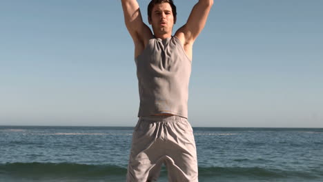 Handsome-man-jumping-on-a-beach