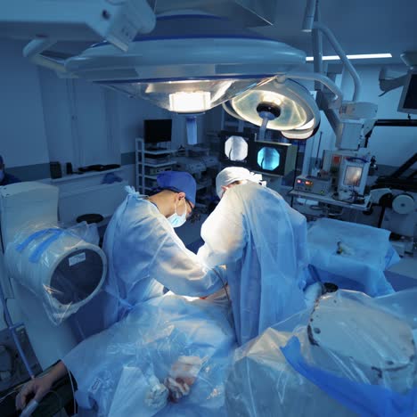 surgery in modern clinic. team of doctors in medical masks and uniform are performing an operation with modern equipment. video from the top