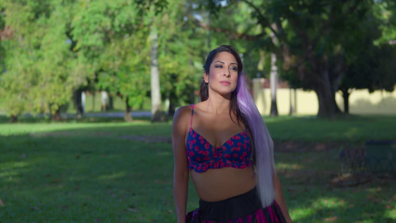 화창한 날 공원에서 비키니 상의를 입은 젊은 여성에게 햇빛이 비친다