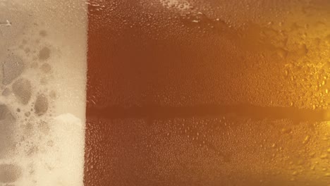 a spinning fresh pint of beer with generous froth on its side in a close up shot