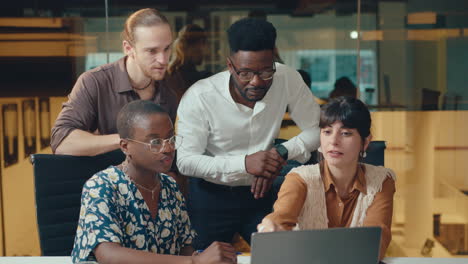 business team discussing project on laptop in modern office