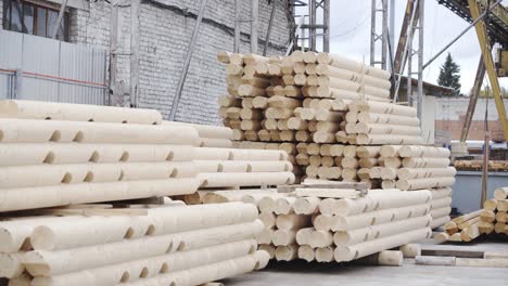 dolly shot of processing of round timber logs for building wooden house. removing bark from logs using a machine. pattern of logs. woodworking factory. lumber industry