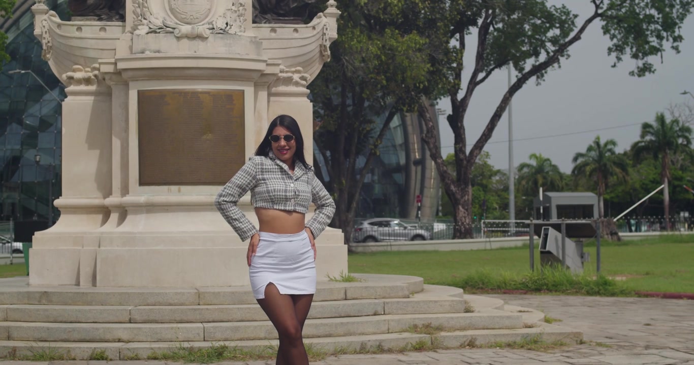 Una ragazza latina chic che indossa una giacca d'effetto e una minigonna trascorre una giornata ventilata esplorando vivaci vicoli cittadini e quartieri artistici.