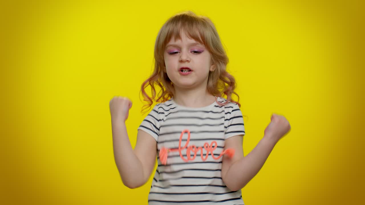 어린 소녀는 권위 있는 모습을 보이고, 손가락을 내려놓고, 심각한 대화를 요구하고, 명령을 내린다.