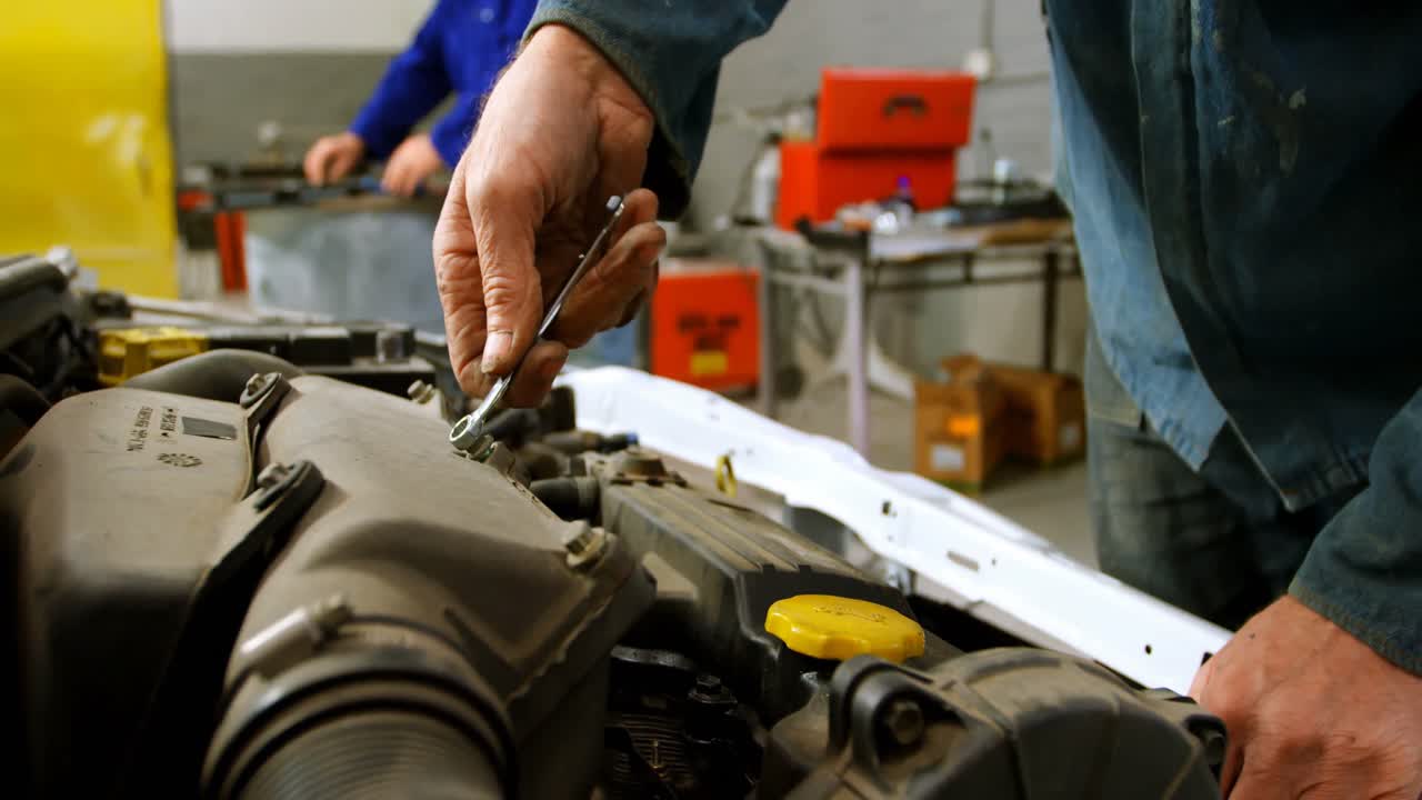 mecánico reparando un coche en el garaje 4k