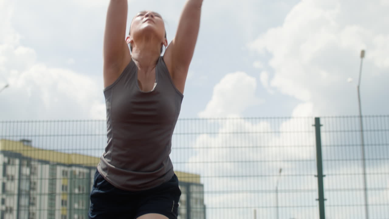 vista inferior de una mujer asiática golpeando una pelota de voleibol.