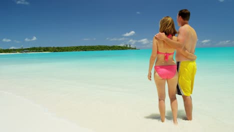 loving young caucasian couple in swimwear on beach