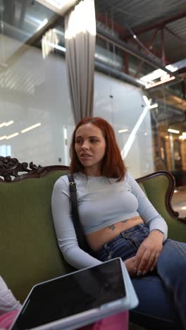 two women in conversation on a sofa in a modern office