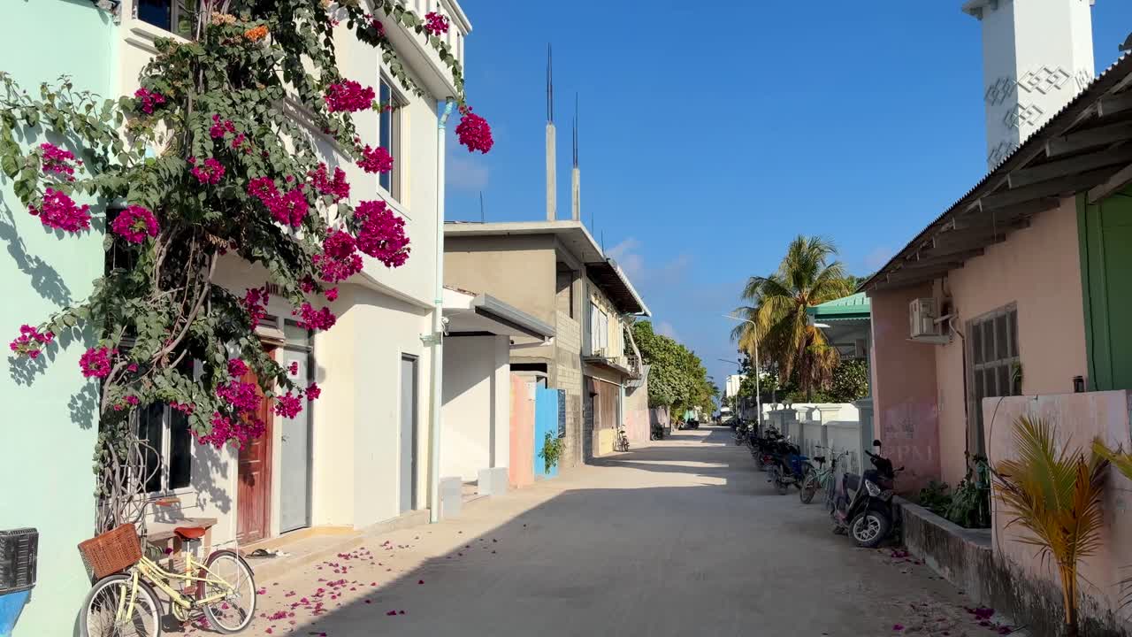 Via residenziale tranquilla sull'isola di Thulusdhoo, Maldive, con case tropicali e biciclette