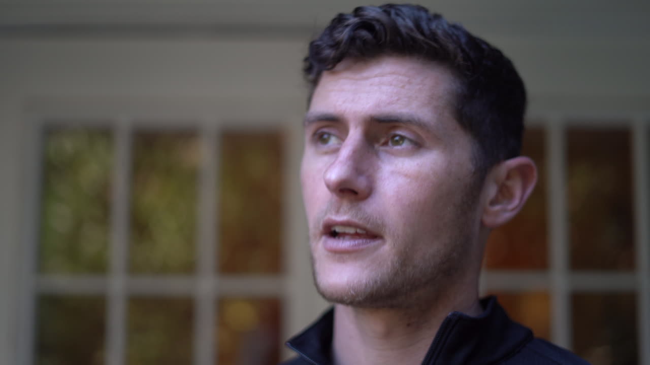 al llegar sano y salvo a casa, un joven se quita la mascarilla y respira aire fresco