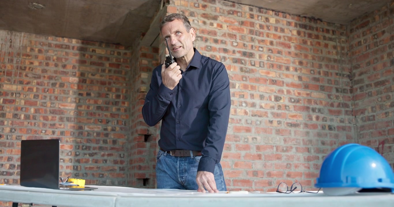 Gerente de construcción usando walkie talkie en la obra