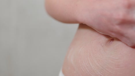 Woman-washing-her-body-with-bath-sponge,-close-up-view