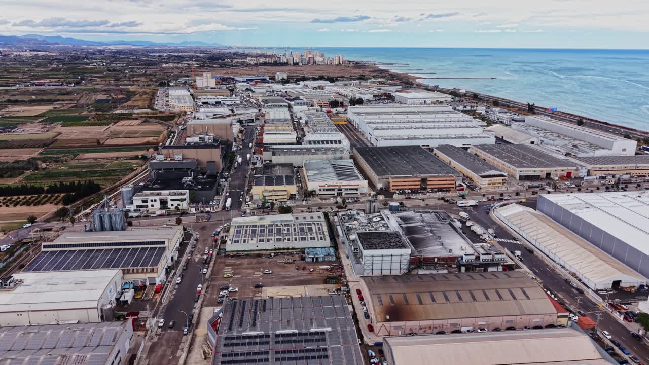 View of industrial area along the coast in Spain with buildings and fields