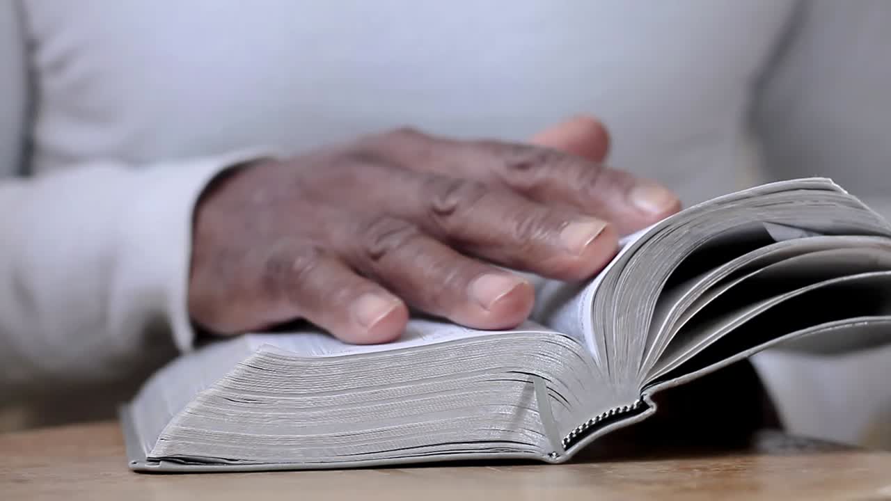 hombre rezando a dios con las manos junto con la biblia hombre caribeño rezando con fondo blanco metrajes