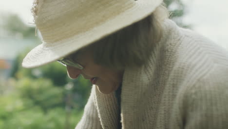 close-up of a woman in a straw hat gardening