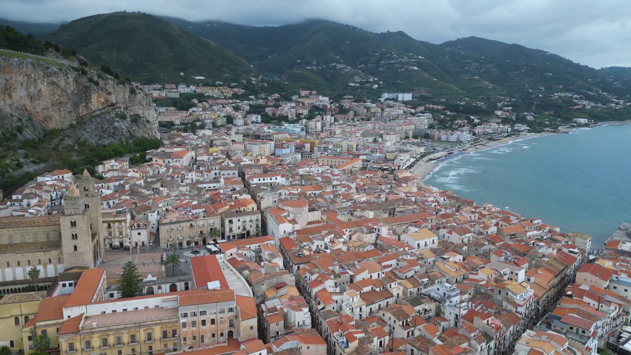 Aerial drone footage of Cefalù, Sicily: historic town, crystal sea, sandy beach and the iconic Rocca. Perfect for travel, landscape and Mediterranean stock footage
