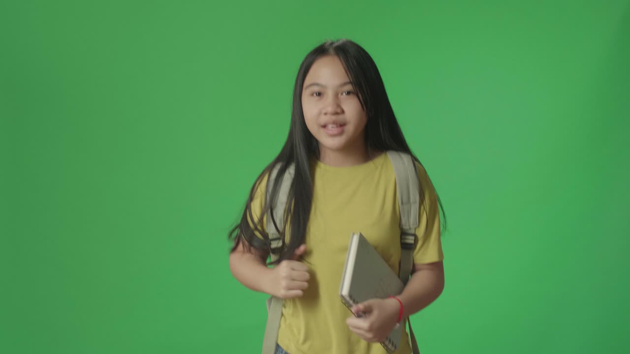 Asian Girl Student Holding Book While Running To School On Green Screen Chroma Key