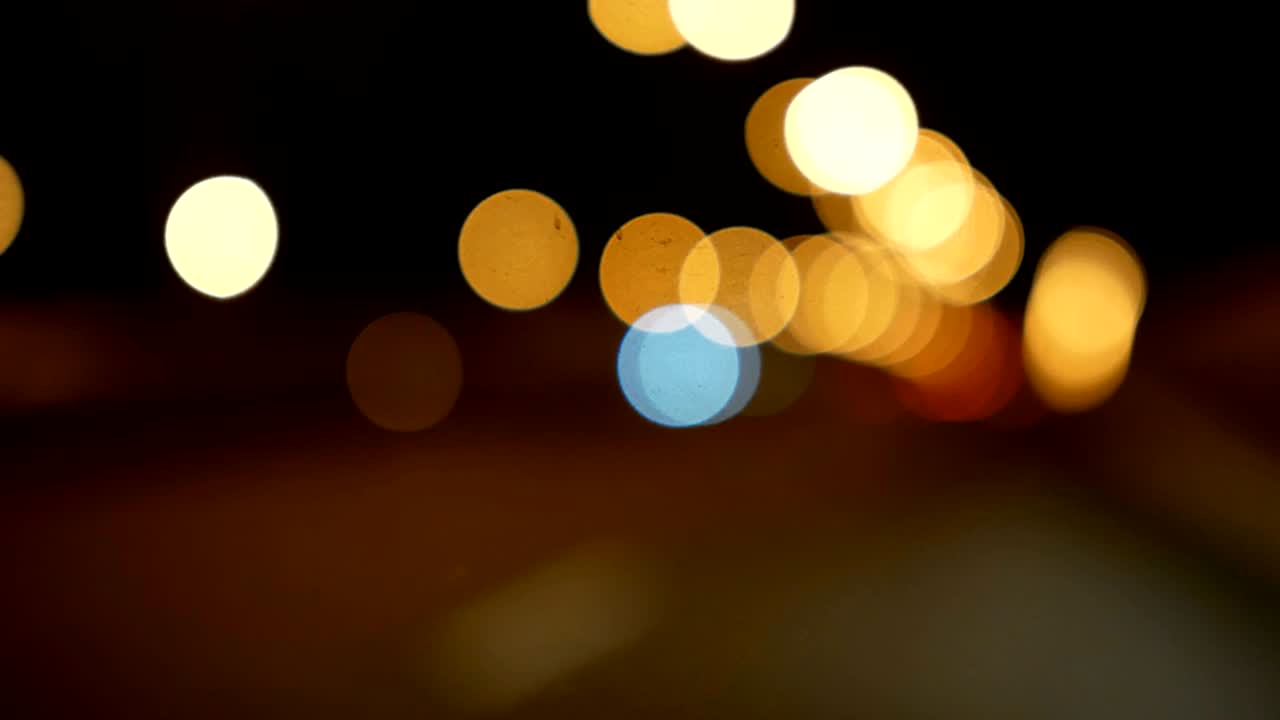 conducir un coche a través de la carretera de la noche, la autopista. luces desenfocadas calle de los ángeles resumen. ciudad fondo borroso. movimientos círculos bokeh de tráfico nocturno.