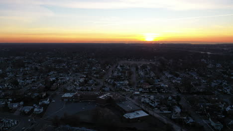 An-aerial-shot-over-a-suburban-neighborhood-during-a-golden-sunrise