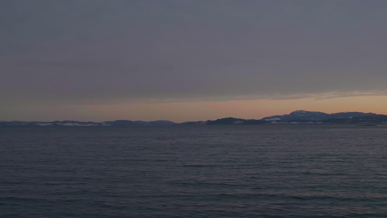 Sunrise over the mountains and a fjord in Norway, that is shot from the moving train