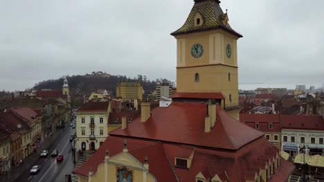 drone-going-up-showing-the-Centrul-Vechi-church-in-the-Council-Square-as-know-as-Piata-Stafului-in-the-city-of-Brasov,-Romania