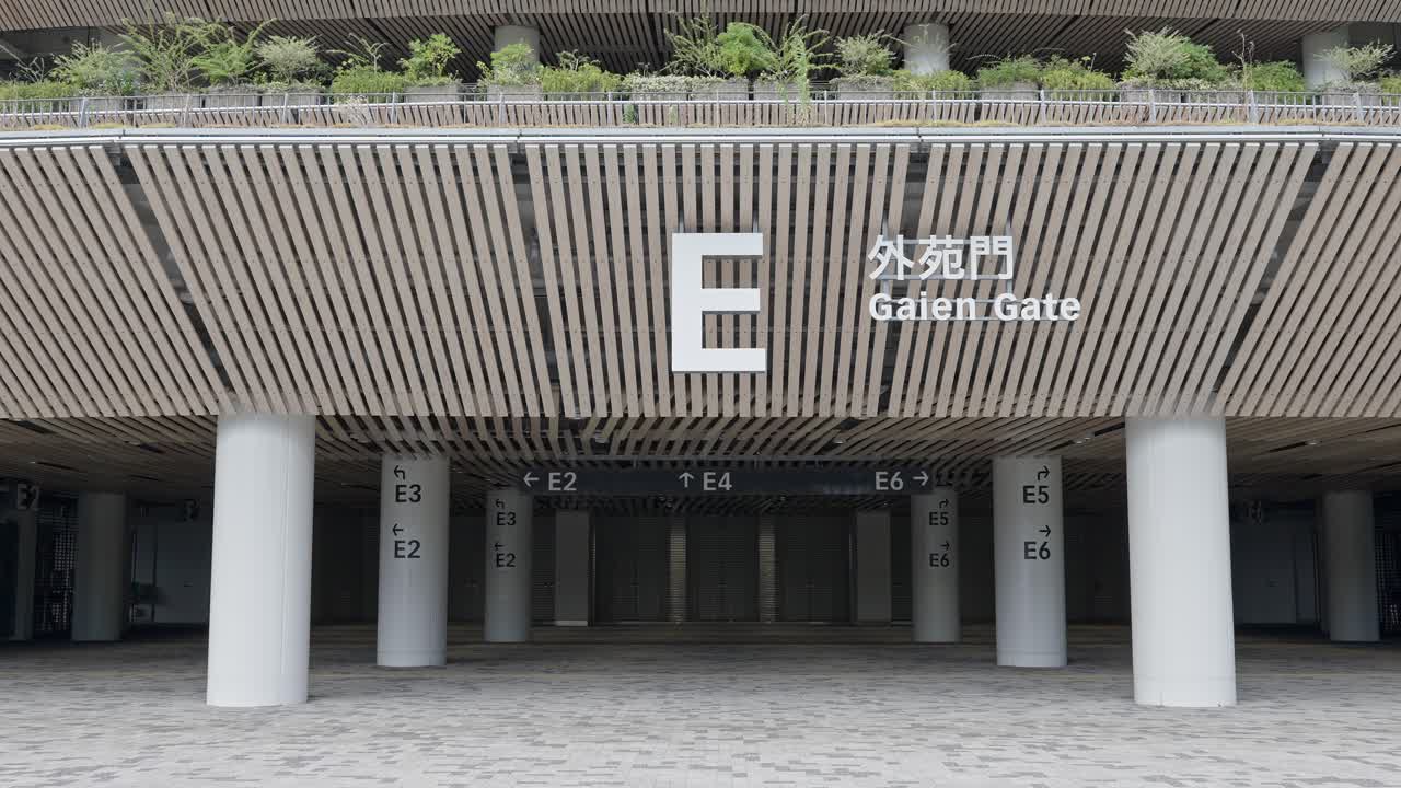 A centered shot of the "E Gaien Gate" entrance to the National Stadium, with modern architecture and clear markings