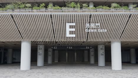 a centered shot of the "e gaien gate" entrance to the national stadium, with modern architecture and clear markings