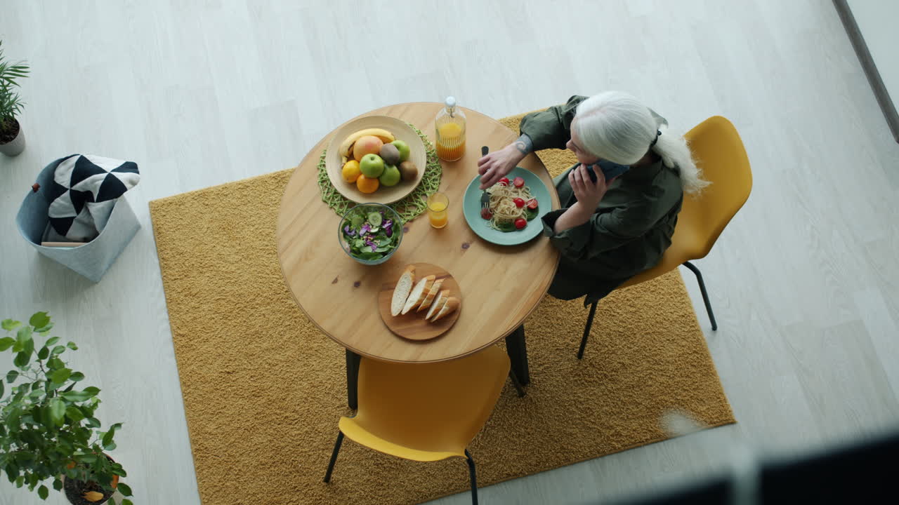Woman Eating Lunch While on a Phone Call