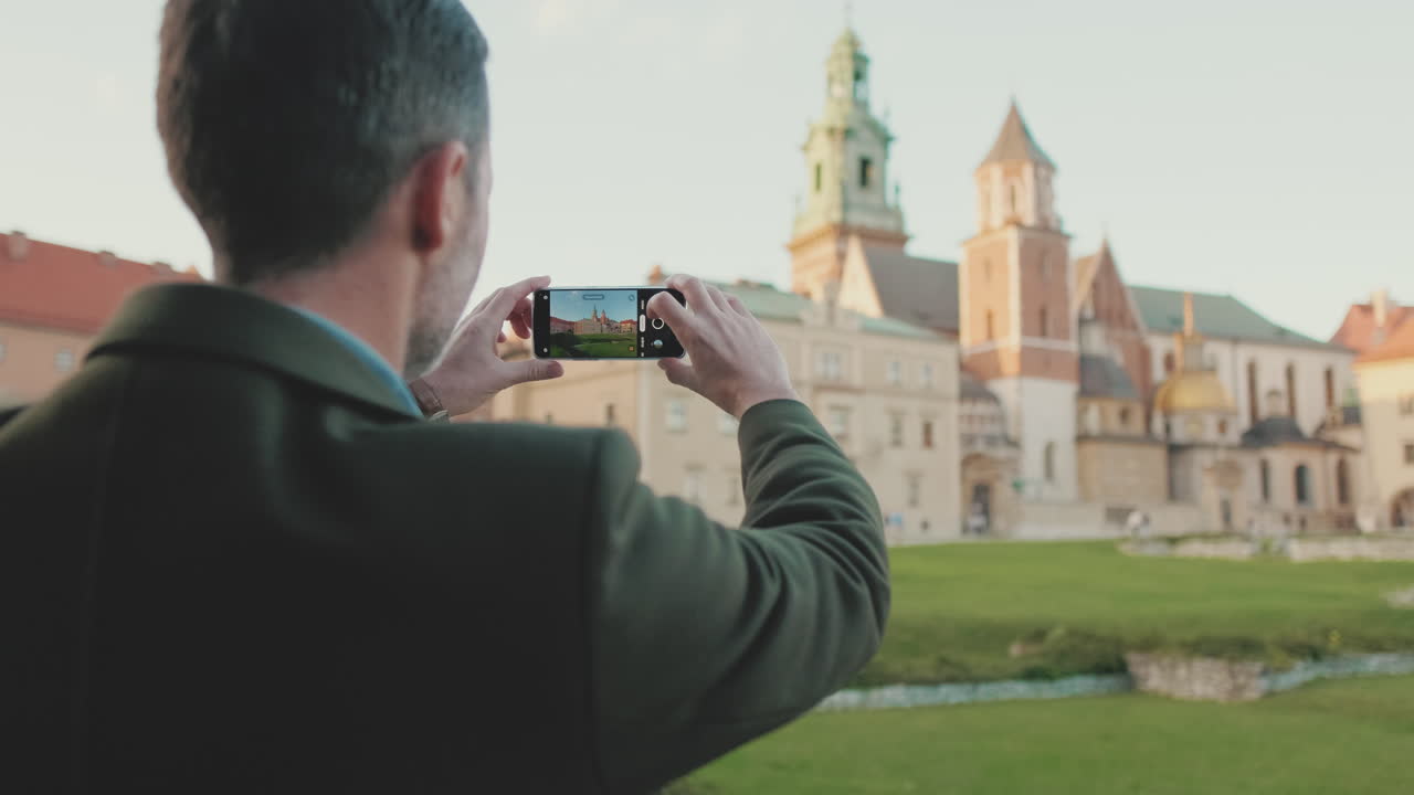 Man taking photo of Wawel Castle in Krakow, Poland